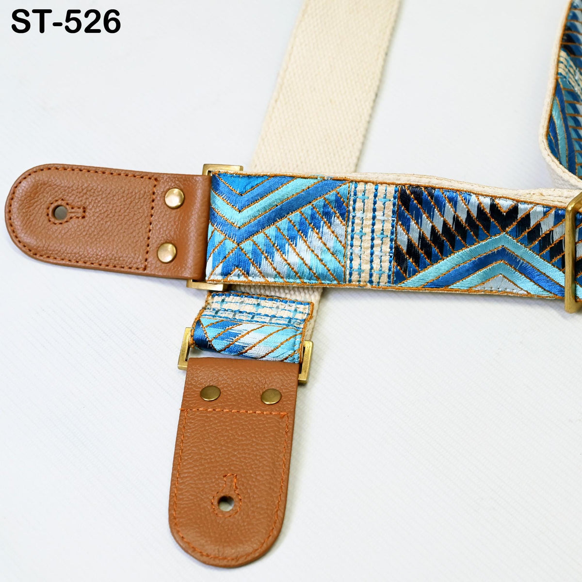 A close-up view of a colorful patterned strap with a leather buckle, likely used for a guitar or other musical instrument.