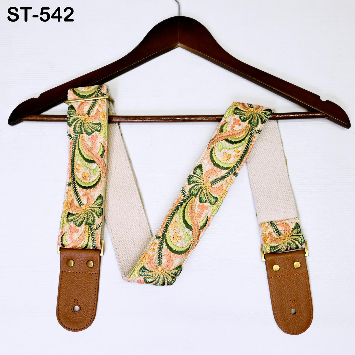 A wooden hanger with a colorful patterned strap attached to it.