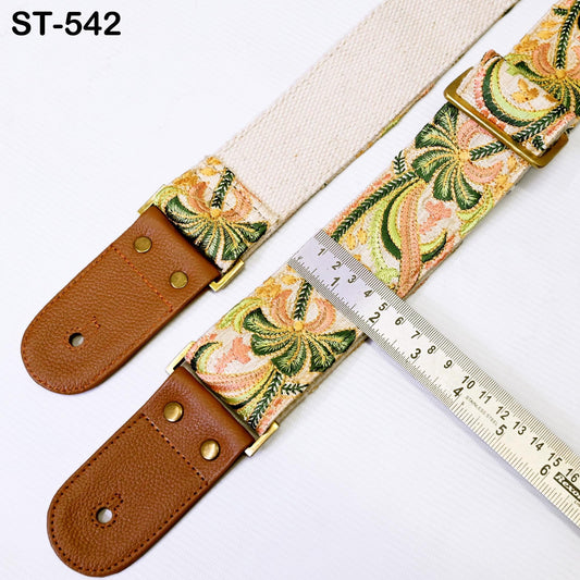 a colorful patterned guitar strap with a ruler placed next to it, indicating the strap's length.