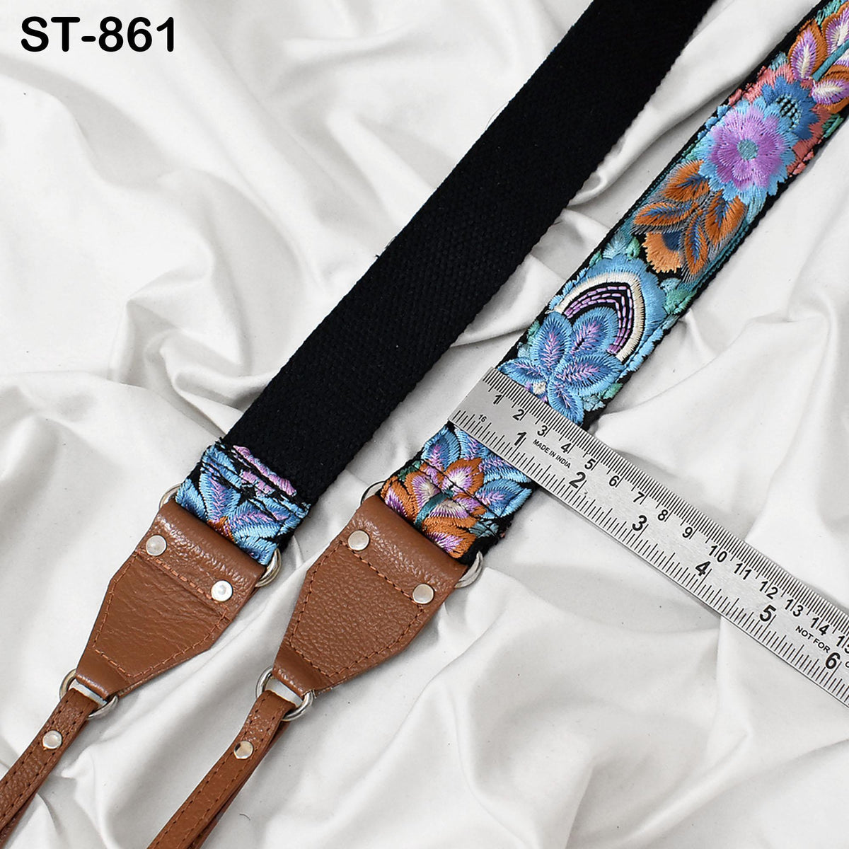 A colorful, patterned strap with a black loop and a ruler placed on top of it, indicating the strap's size.