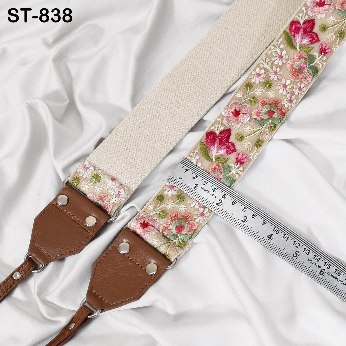 A floral embroidered strap with a ruler placed next to it, indicating the strap's length.