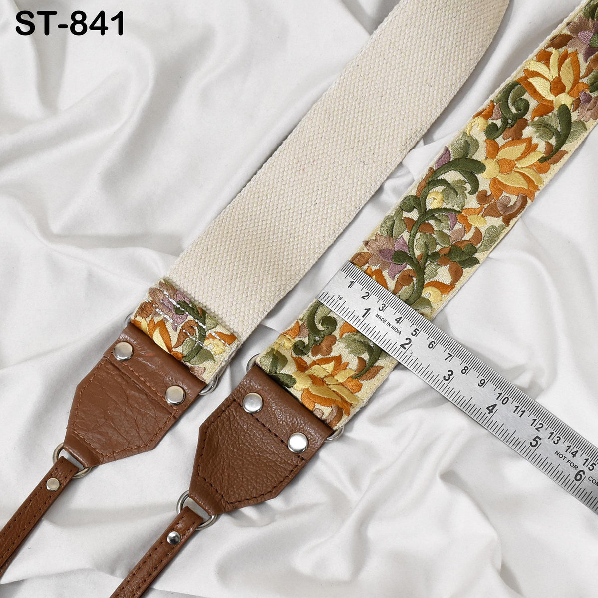 a strap with a floral pattern and a ruler placed on top of it, indicating the strap's length.