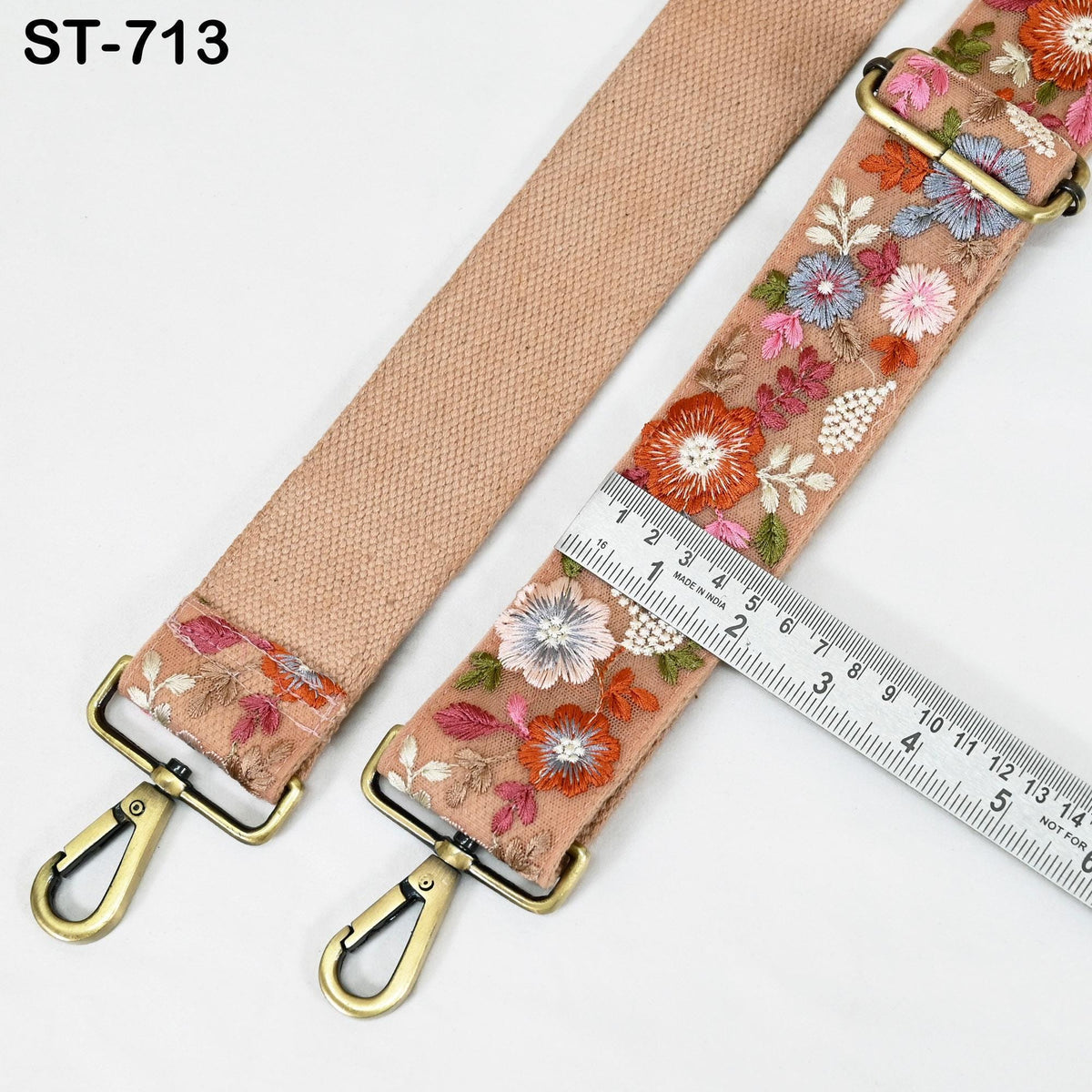 a floral embroidered strap with a ruler placed next to it, indicating the strap's length.