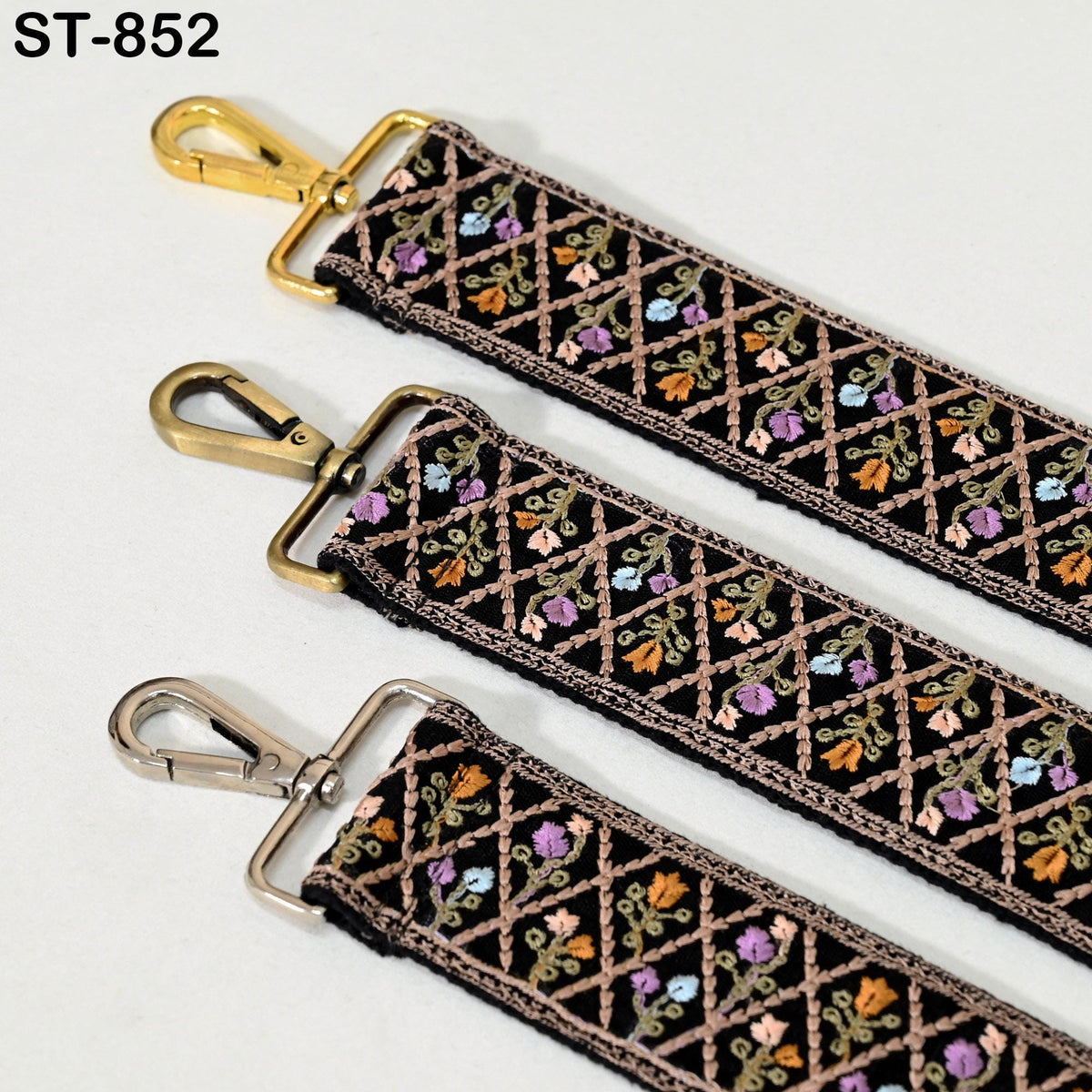 three straps with decorative floral patterns, each with a metal clasp and hook.