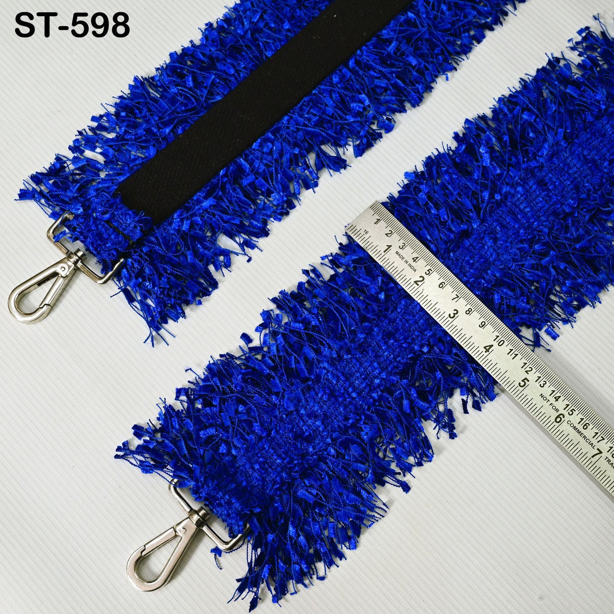 a blue, fuzzy strap with a black strap attached to it, and a ruler placed next to it to measure the strap's length.