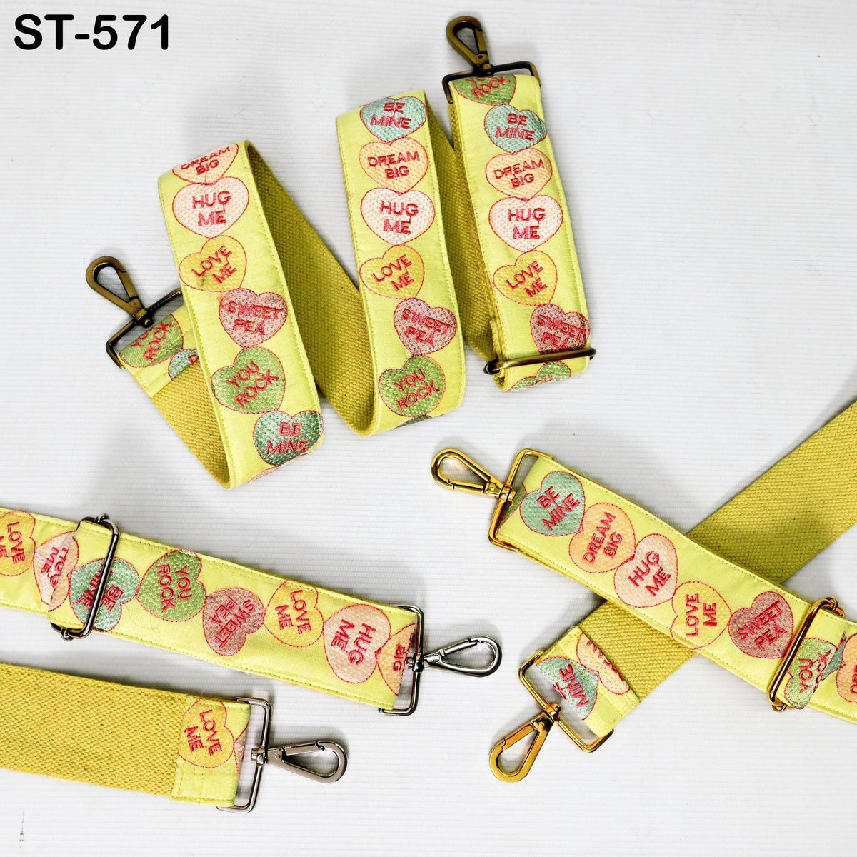 a collection of yellow straps with heart-shaped designs and various motivational phrases printed on them.