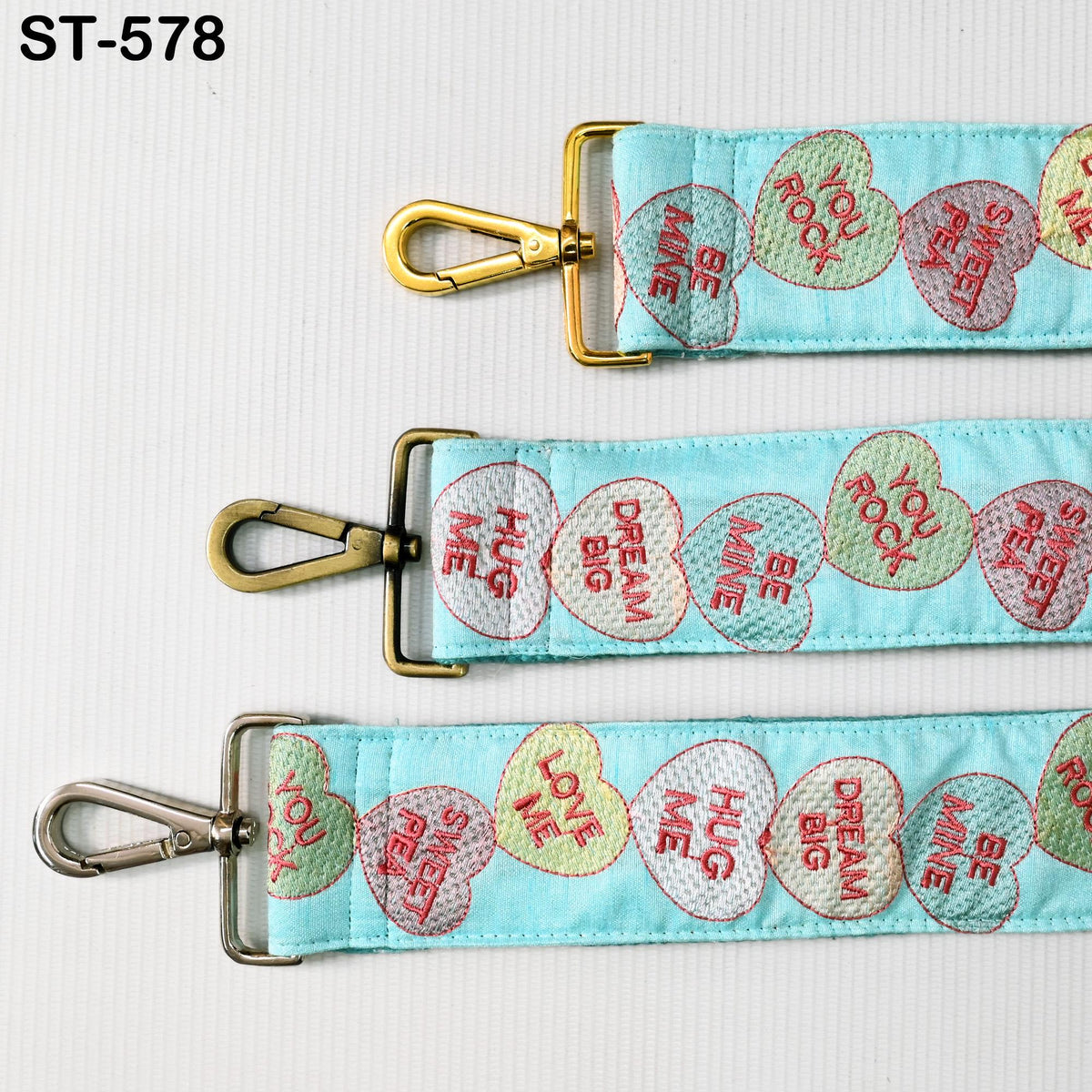 three heart-shaped straps with different messages printed on them.