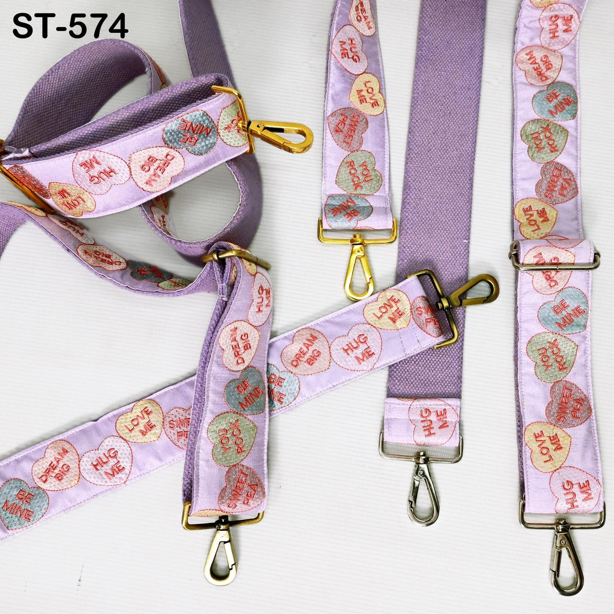a collection of purple straps with heart-shaped embroidered designs on them. The straps appear to be made of fabric and are attached to metal loops.