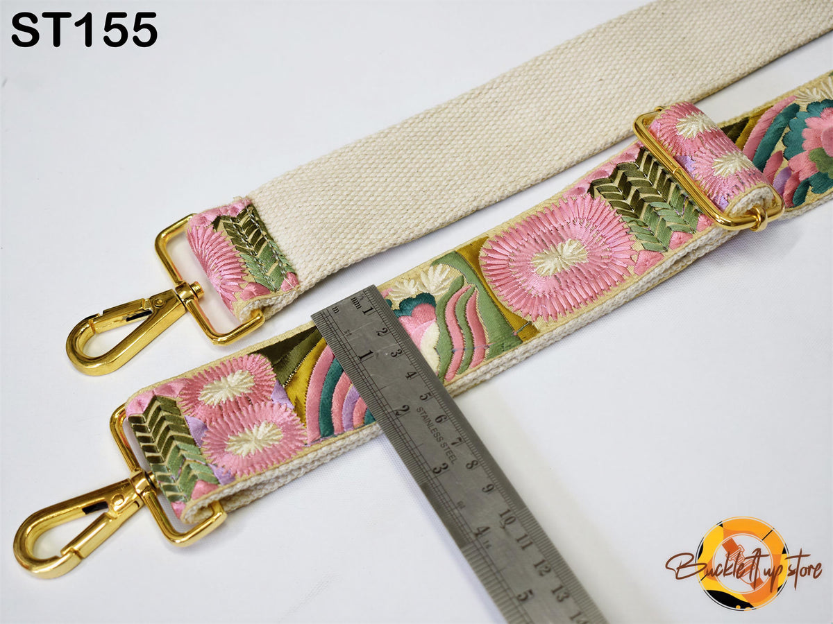 a strap with a floral pattern and a ruler placed next to it, indicating the strap's size.