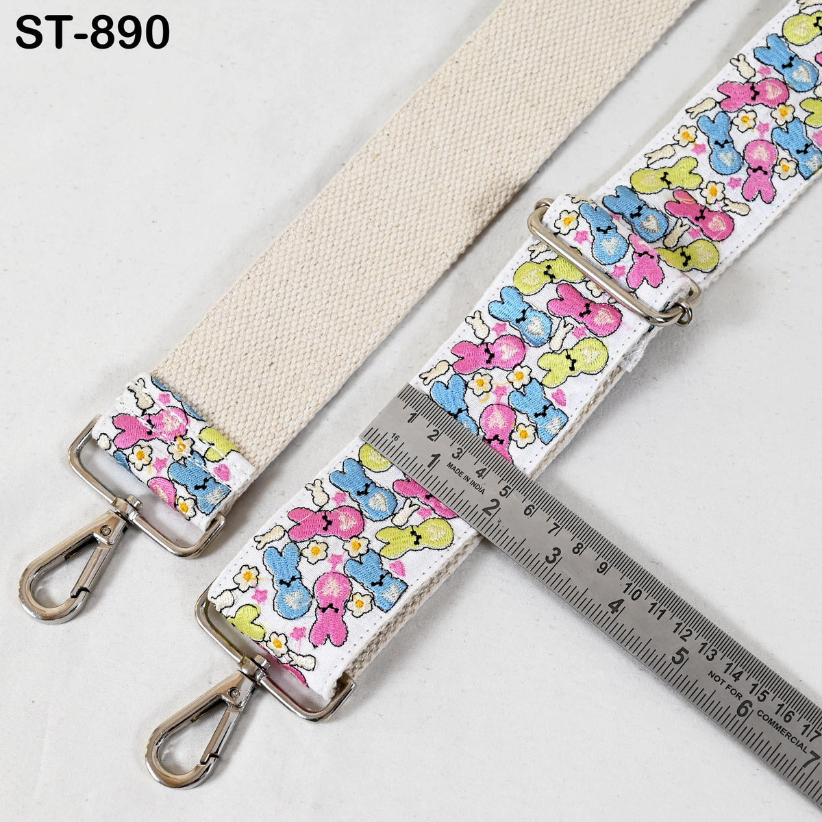 a colorful strap with a floral pattern, and a ruler is placed next to it, indicating the strap's length.