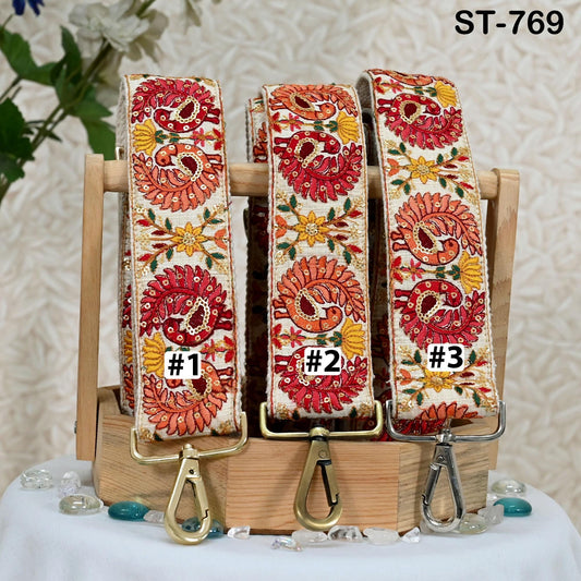Three colorful, patterned straps are displayed on a wooden stand, each with a metal clasp.