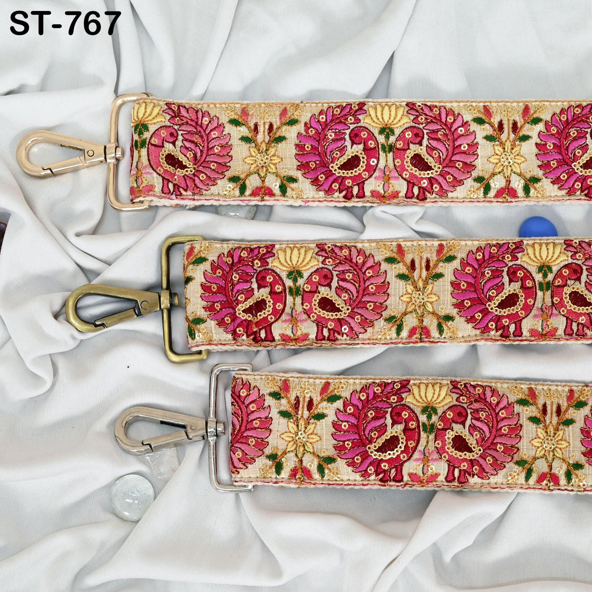 a decorative fabric strap with a floral pattern in shades of pink and gold. The strap appears to be made of a soft, plush material and is displayed on a white fabric background.