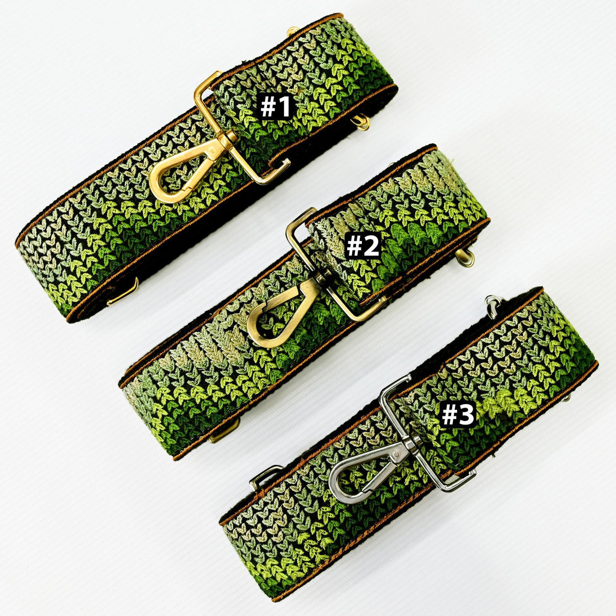 three green and gold straps with numbers 1, 2, and 3 printed on them, indicating the order or position of the straps.