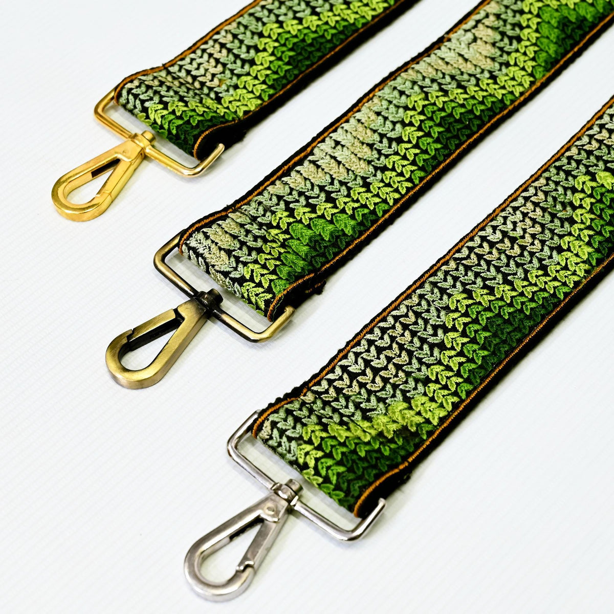 three colorful straps with metal hooks, arranged in a row.