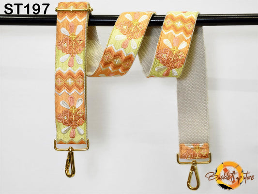 a colorful, patterned strap with a gold metal buckle, hanging on a black pole.