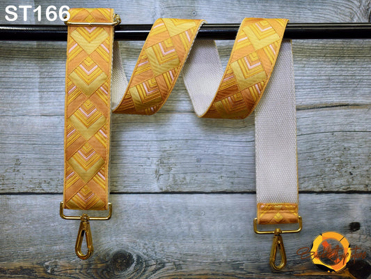 a pair of yellow and white patterned straps hanging on a wooden surface.