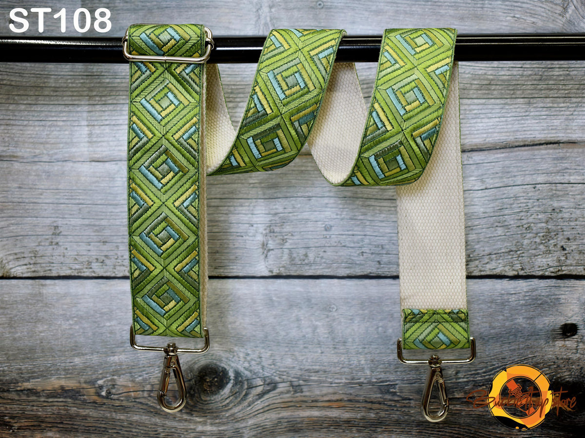 a green and white patterned strap hanging on a wooden surface.