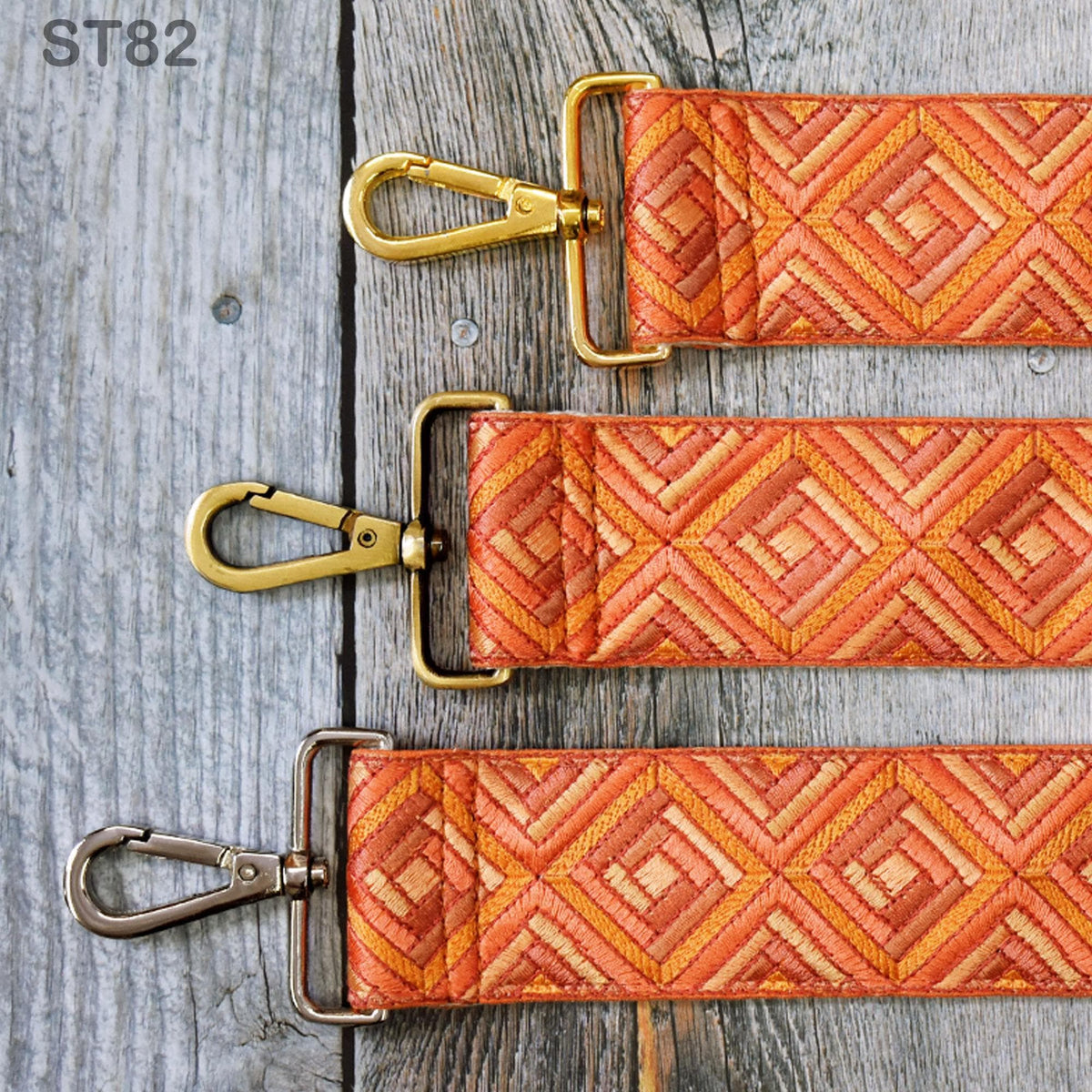 three straps with a geometric pattern in shades of orange and brown, laid out on a wooden surface.