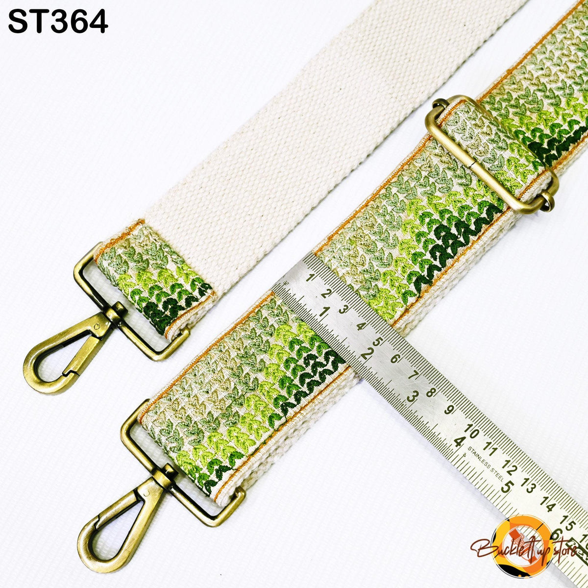 a strap with a green and white patterned design, and a ruler is placed next to it, indicating the strap's length.