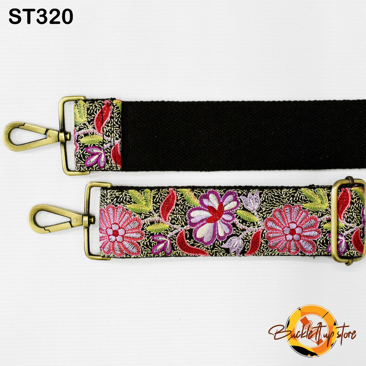 a black strap with a floral pattern on it, attached to a gold-colored metal clasp.