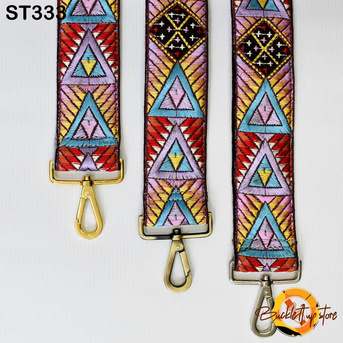 Three colorful, patterned straps with metal hooks and buckles, arranged side by side.