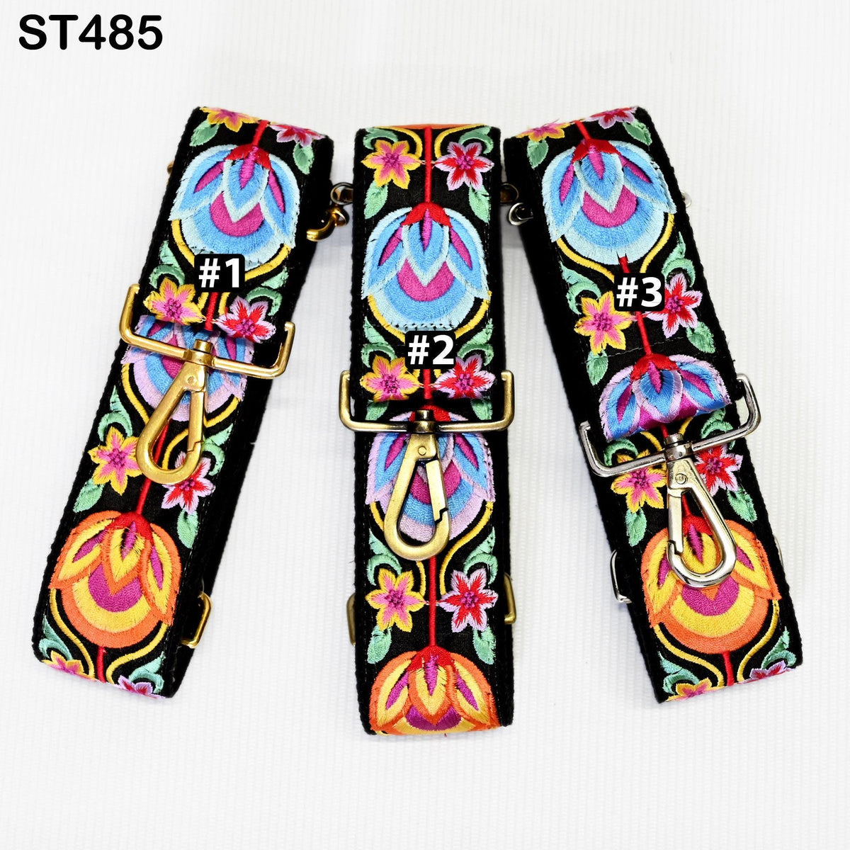 three colorful, embroidered straps with floral patterns and numbers on them.
