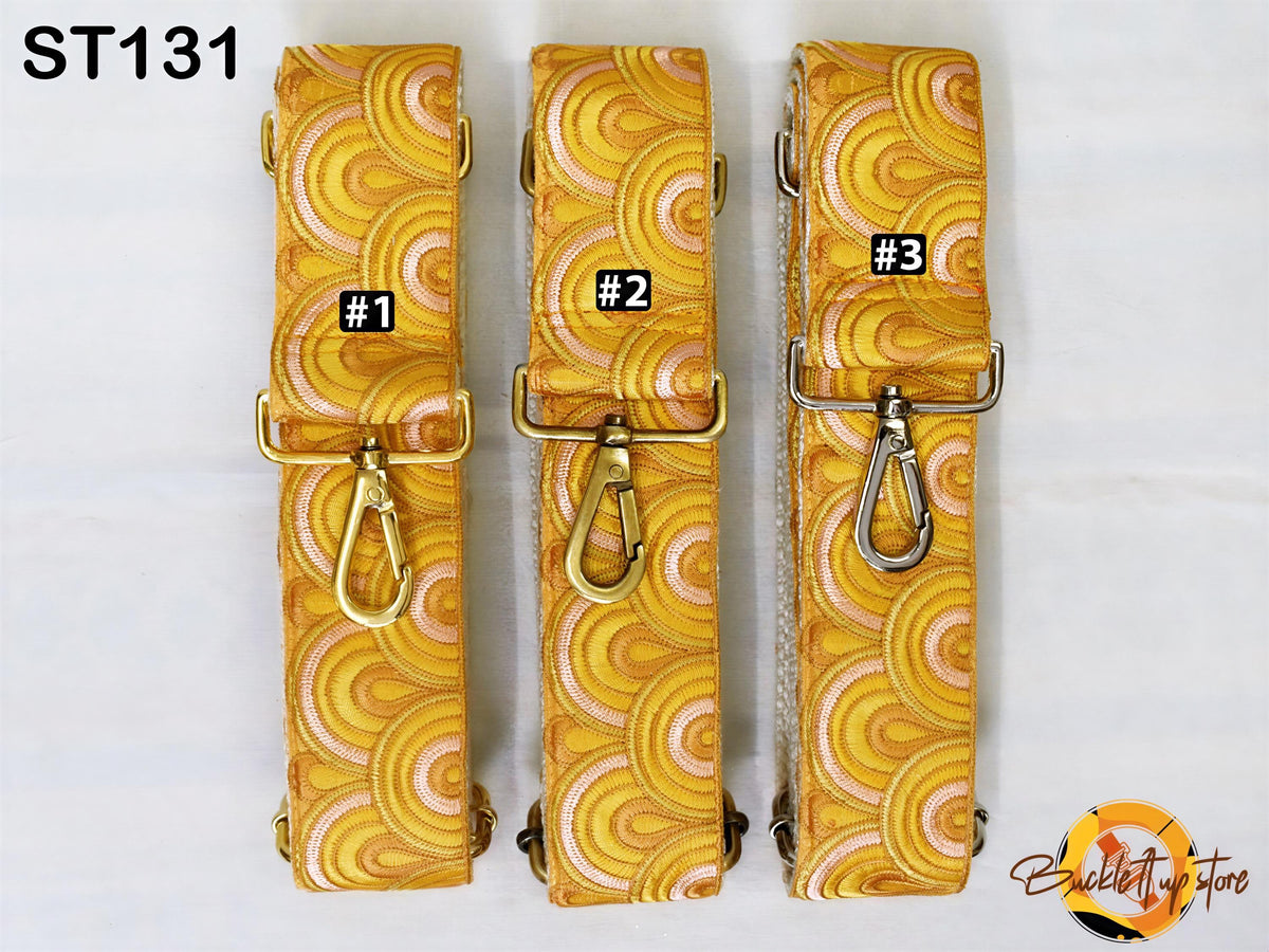 Three yellow and gold patterned straps with metal clasps, each with a different number printed on it.