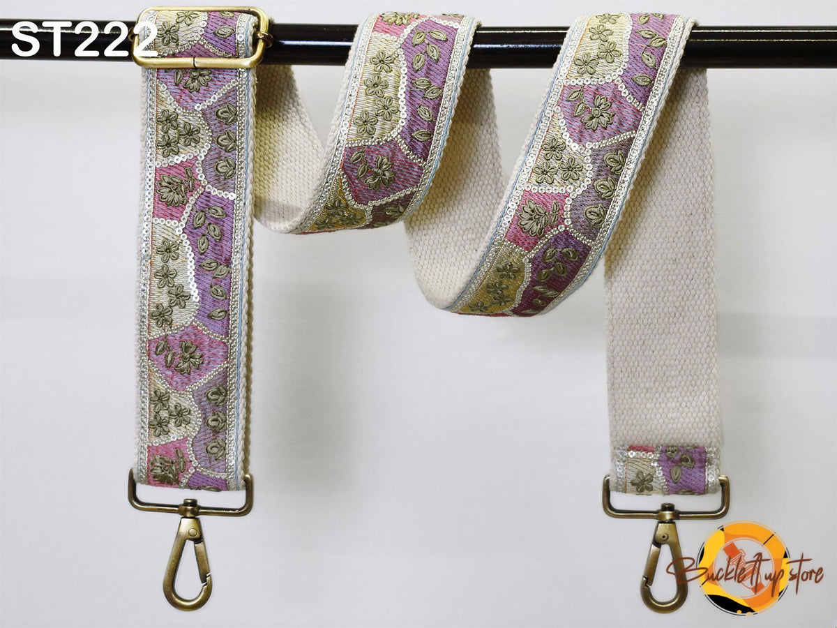 a decorative fabric strap with a floral pattern, hanging on a black bar.
