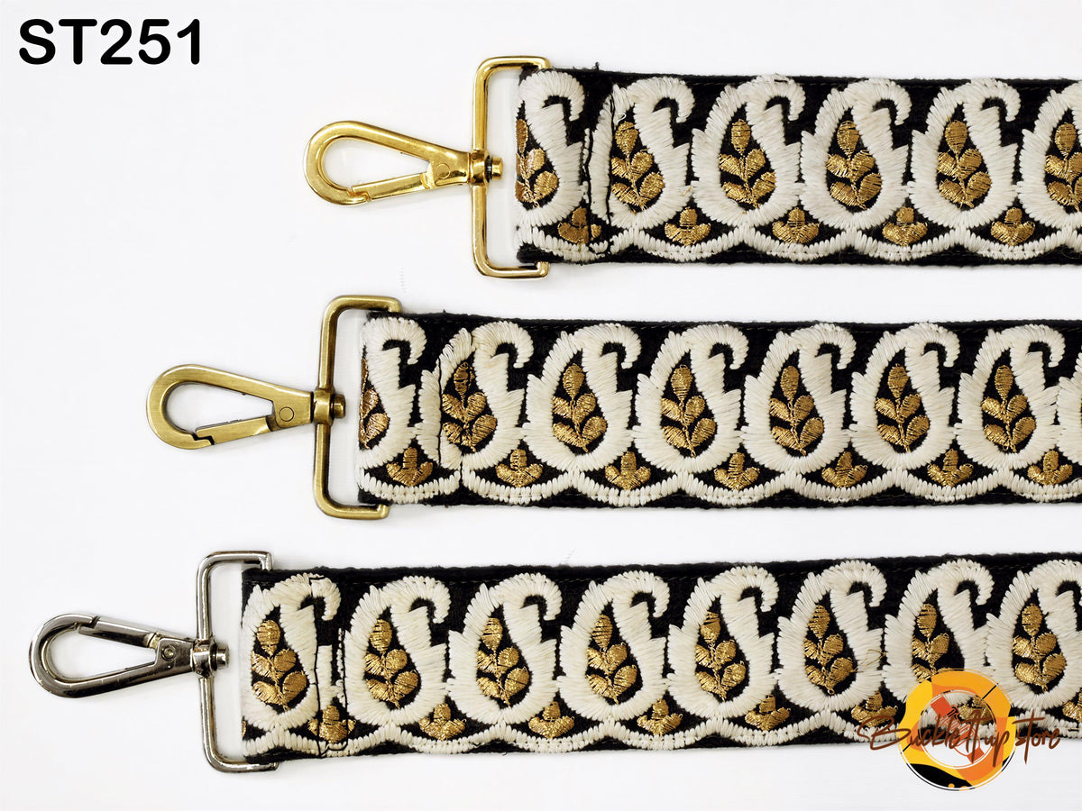 three straps with a paisley pattern in black and gold colors. The straps have a metallic clasp and a metal buckle.