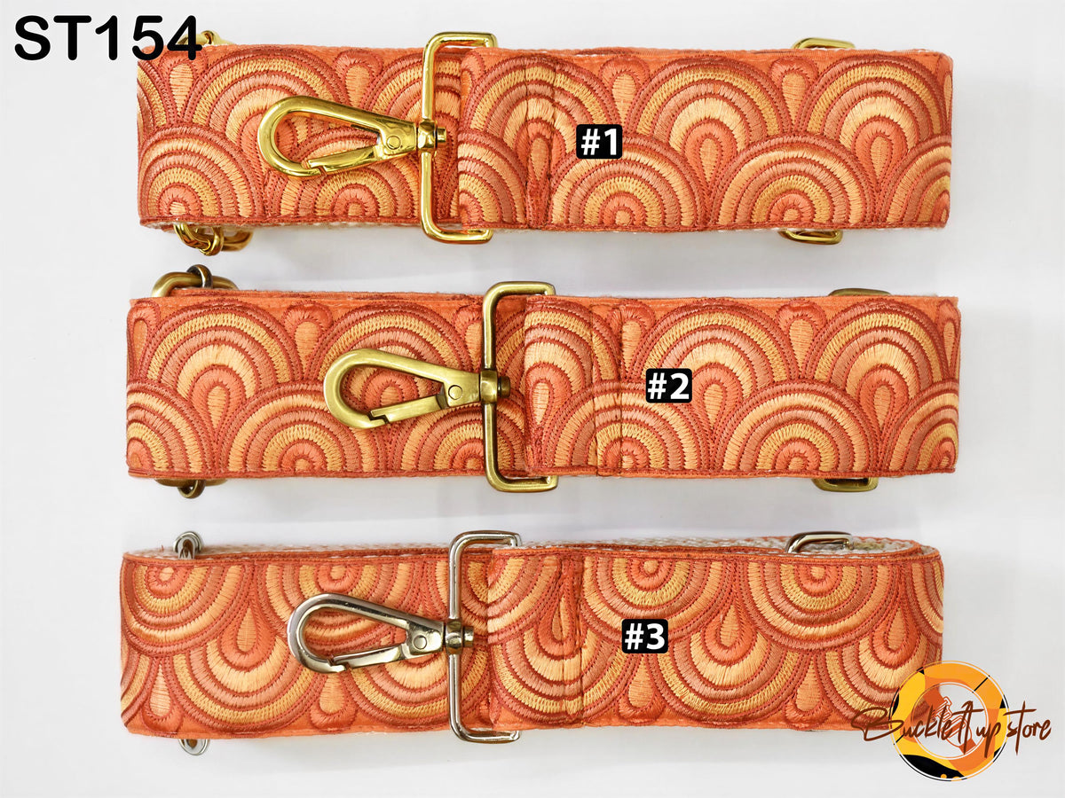 three straps with a repeating pattern of orange and yellow circles, each with a gold buckle and metal loop. The straps are arranged in a row, with the top one being the largest and the bottom one being the smallest.