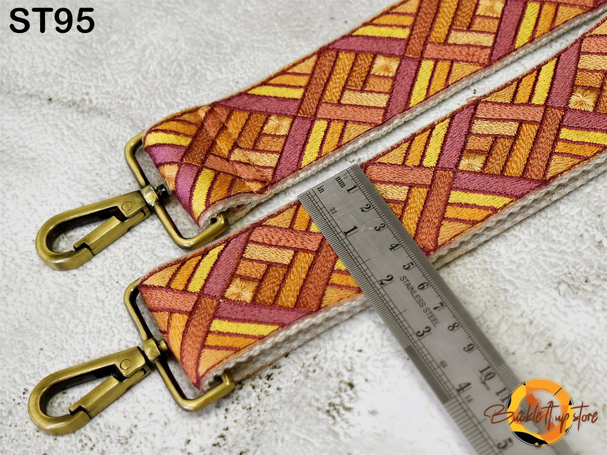 a colorful patterned strap with a metal ruler placed next to it, indicating the strap's size.