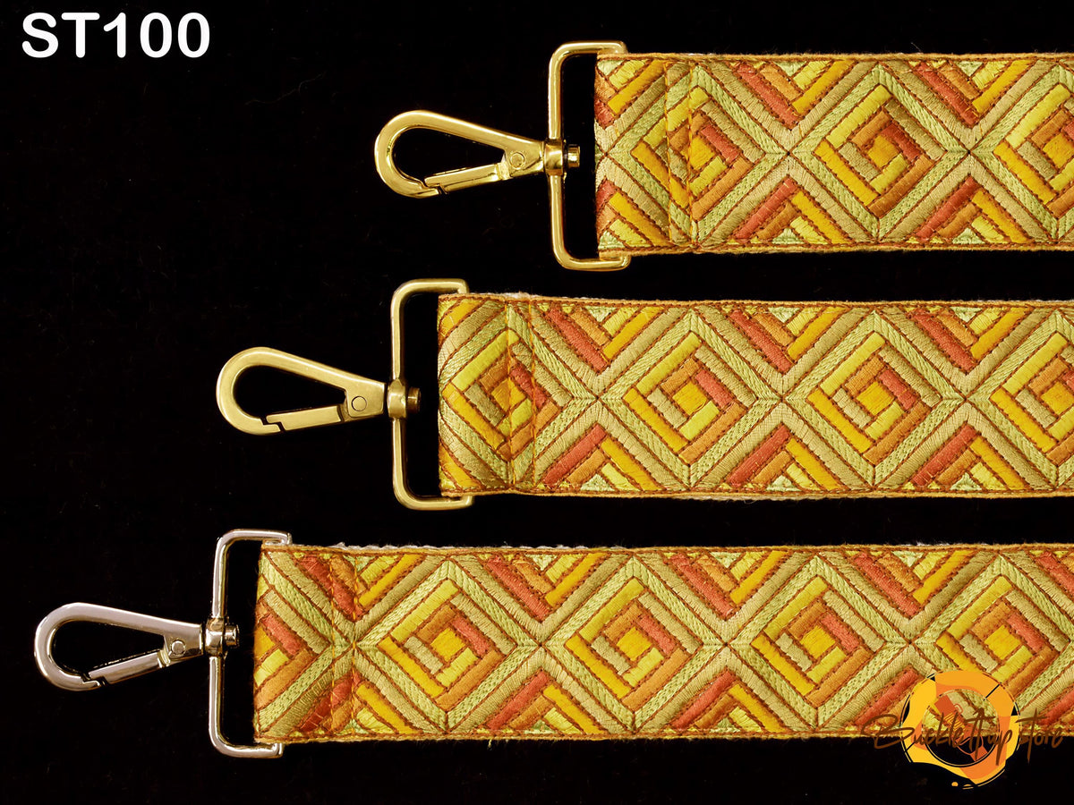 three straps with a geometric pattern in shades of yellow and orange. The straps have metal clasps and buckles, and the straps appear to be made of fabric.