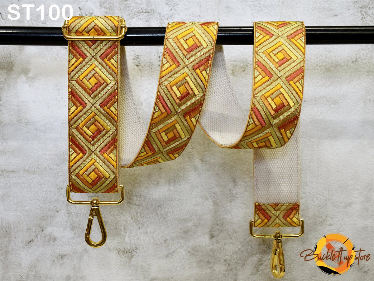 a colorful strap with a geometric pattern, hanging on a black rod.