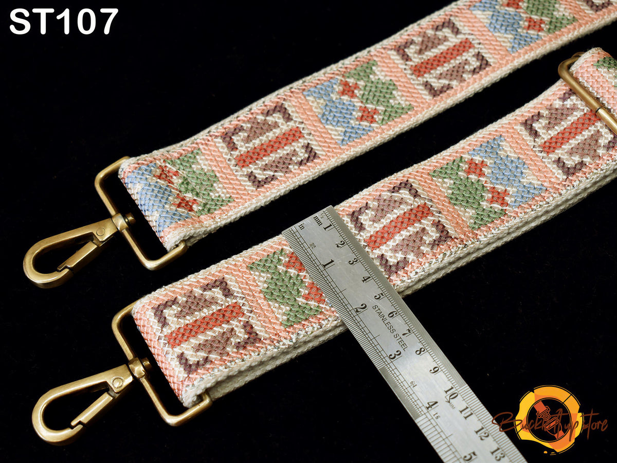 a colorful, patterned strap with a ruler placed on top of it, indicating the strap's length.