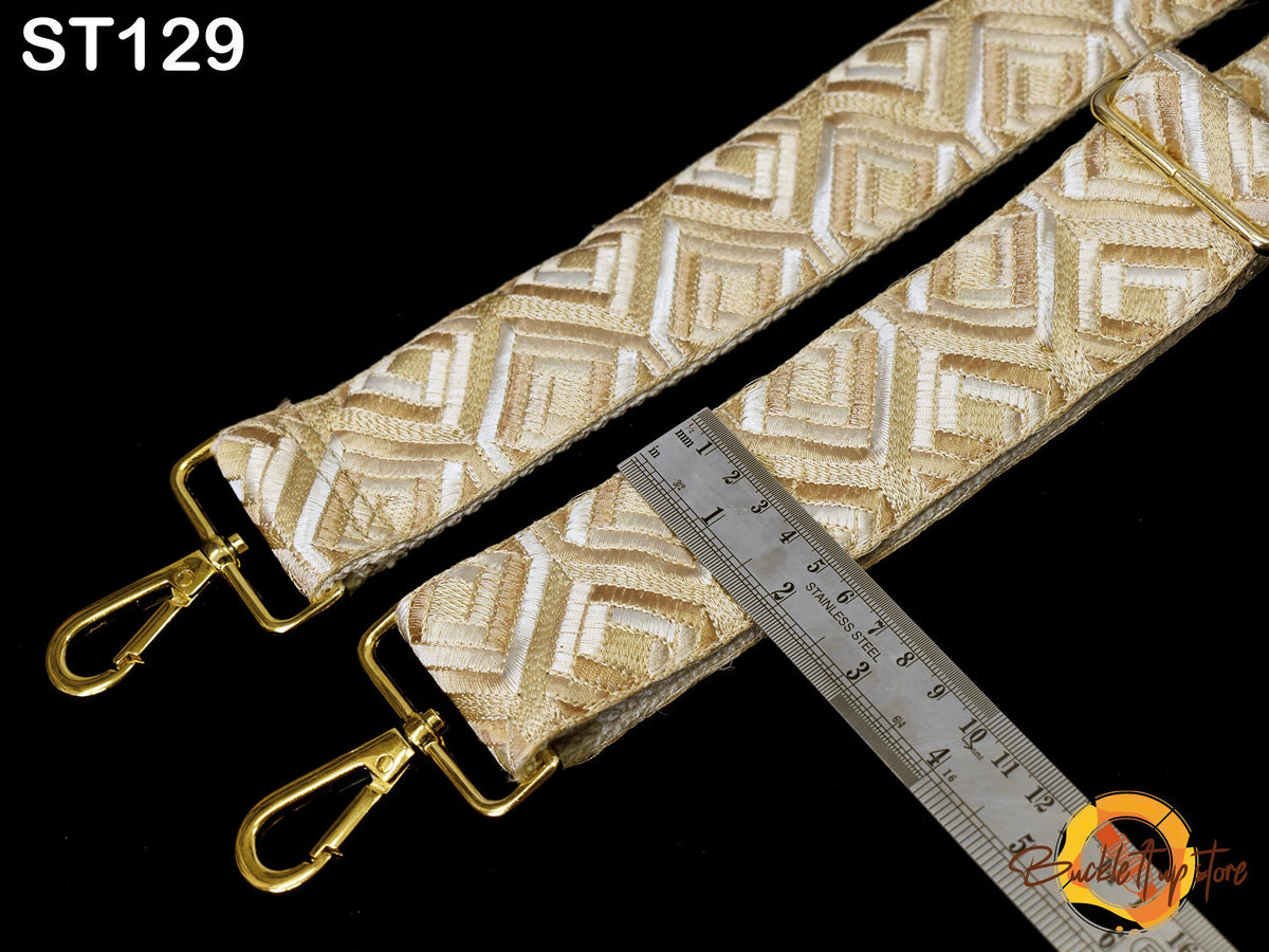 a close-up view of a gold-colored strap with a ruler placed next to it, indicating the strap's size or length.