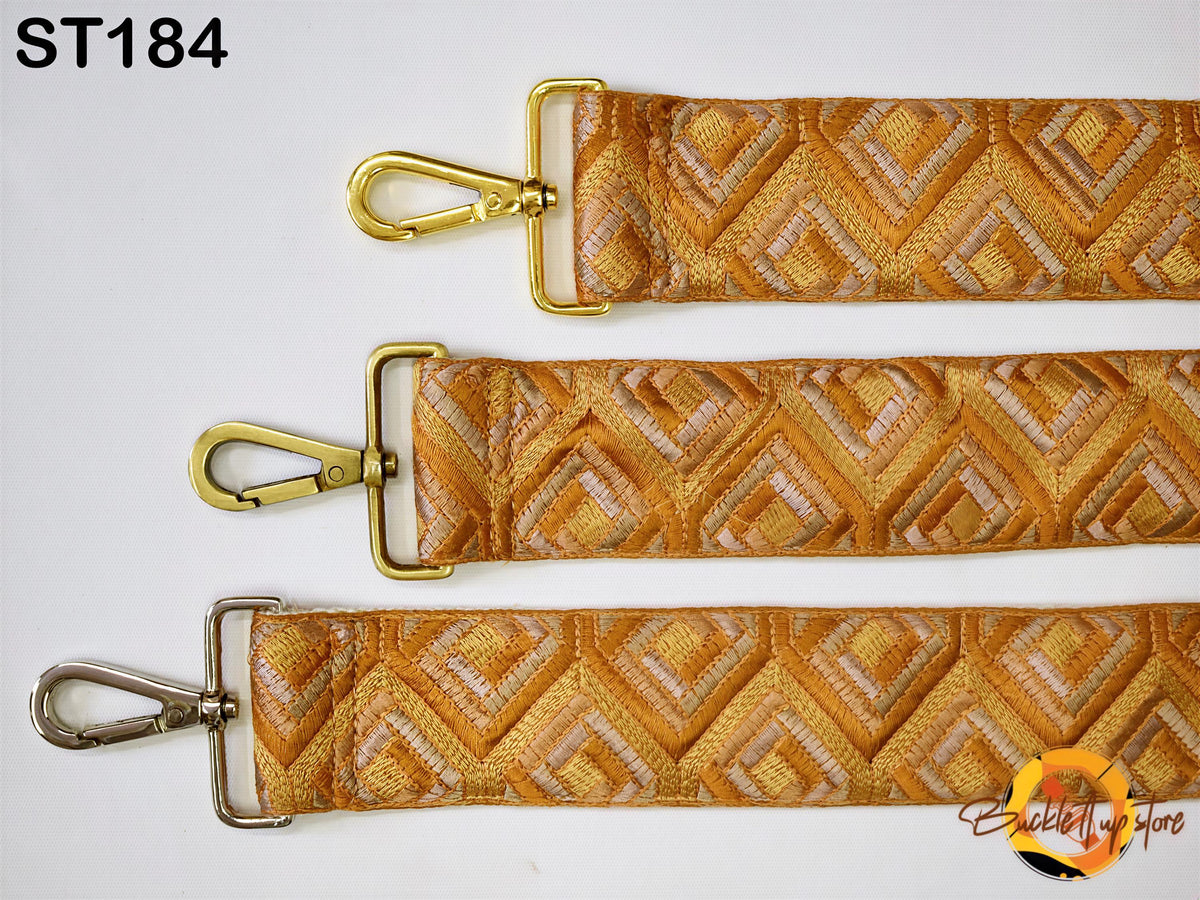 three straps with gold-colored metal hooks and a geometric patterned fabric.