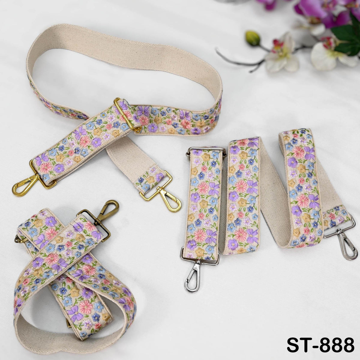 a collection of floral-patterned straps and buckles, including a large strap with a floral design and several smaller straps with similar patterns. The straps are arranged on a white surface, with some of them attached to a floral background.