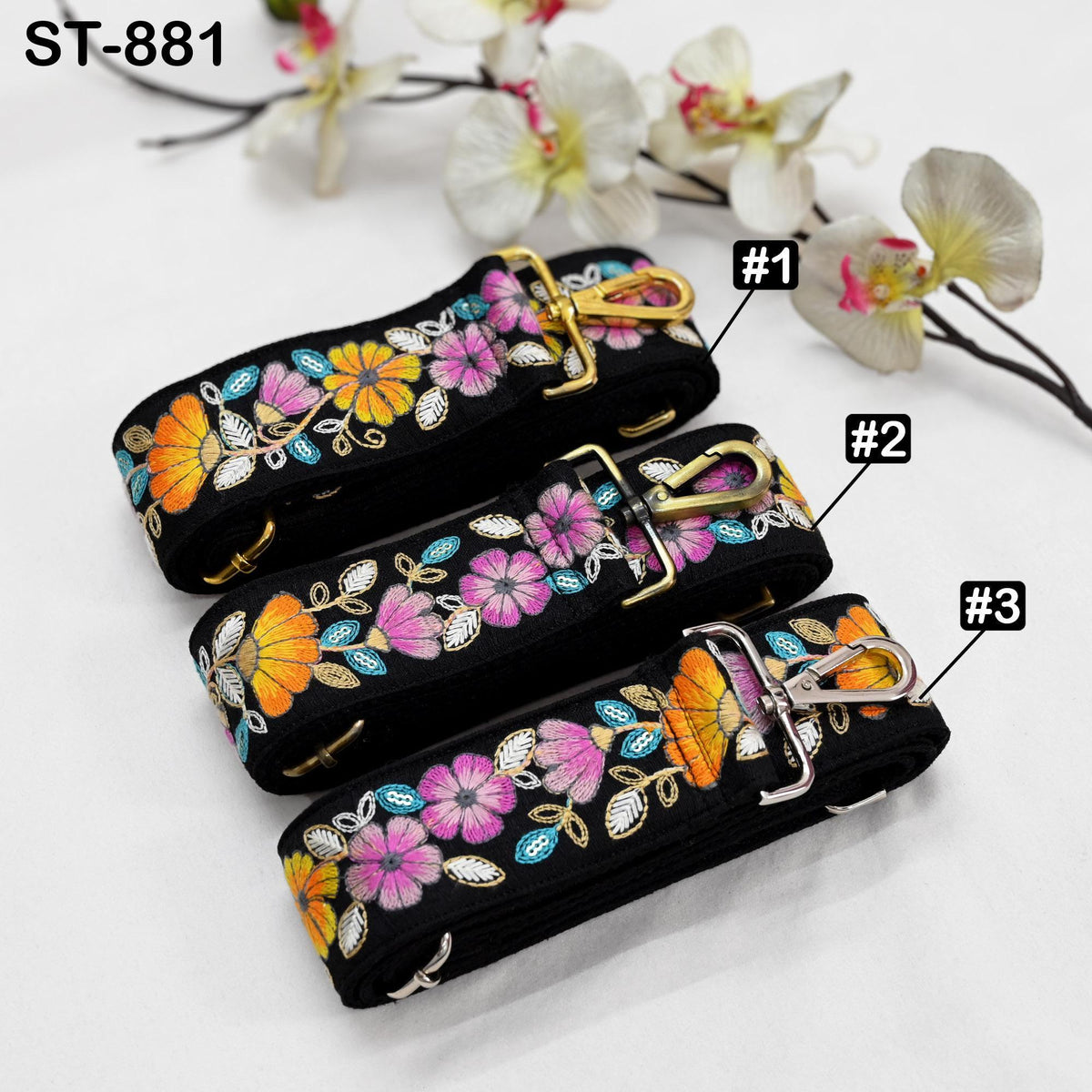 three colorful floral straps with gold hardware, arranged on a white surface.