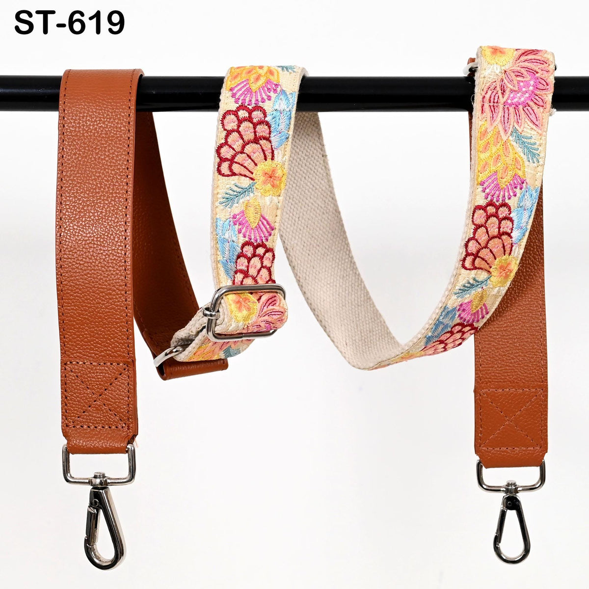 two colorful straps hanging on a black pole. The straps appear to be made of leather and have a floral pattern.