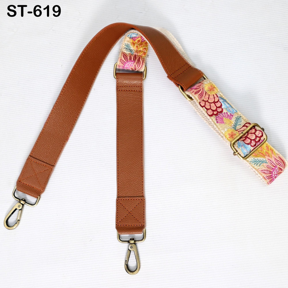 A brown leather strap with a floral pattern, featuring two metal hooks and a buckle closure.