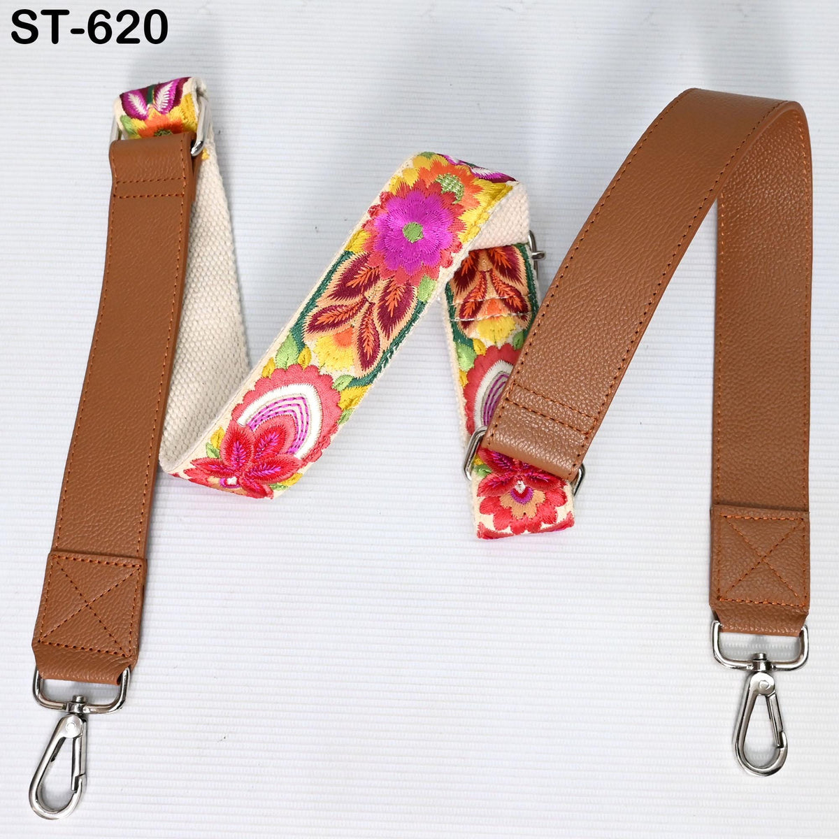 a pair of brown leather straps with colorful floral patterns, attached to a white background.