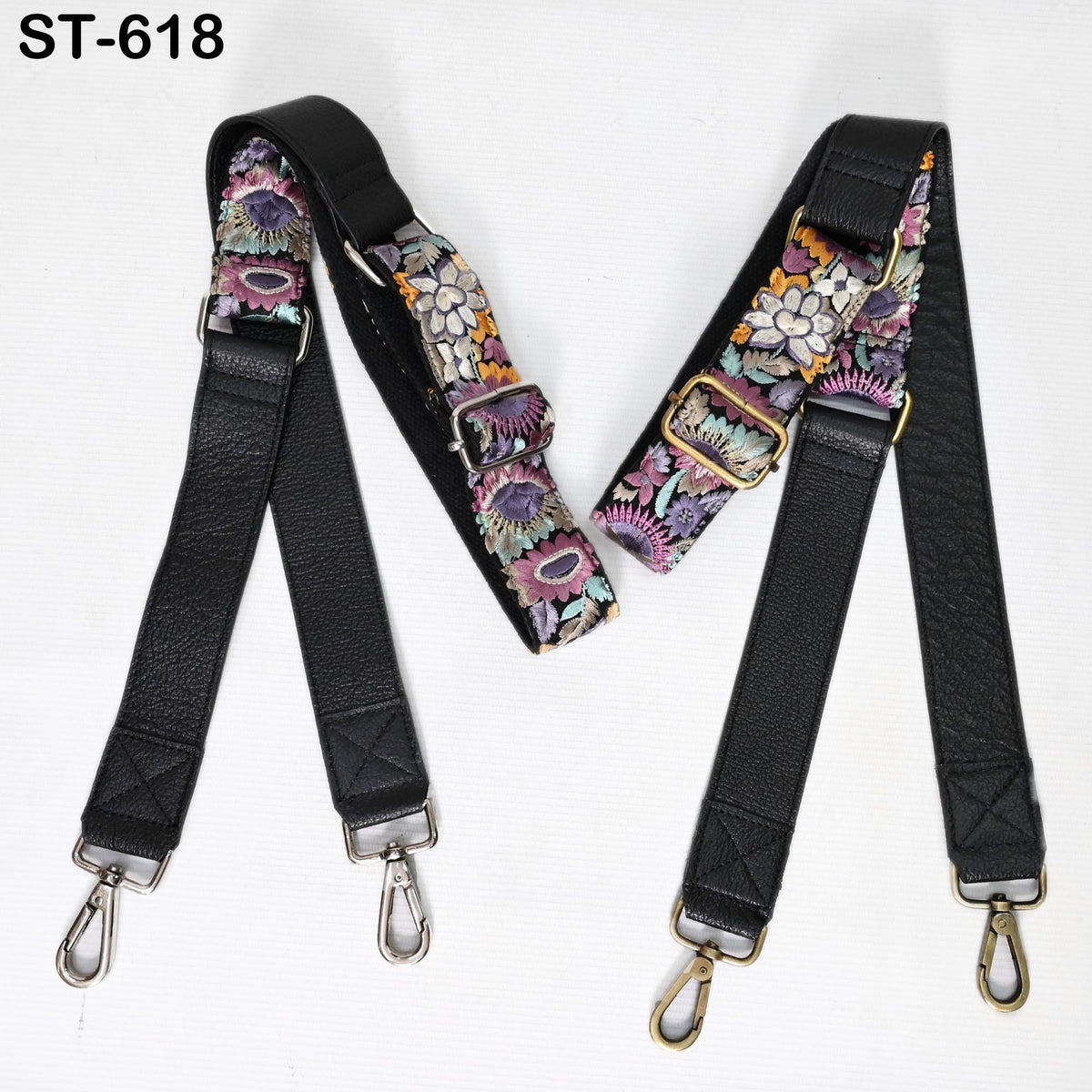 two black leather straps with floral patterns, each with metal hooks and buckles.