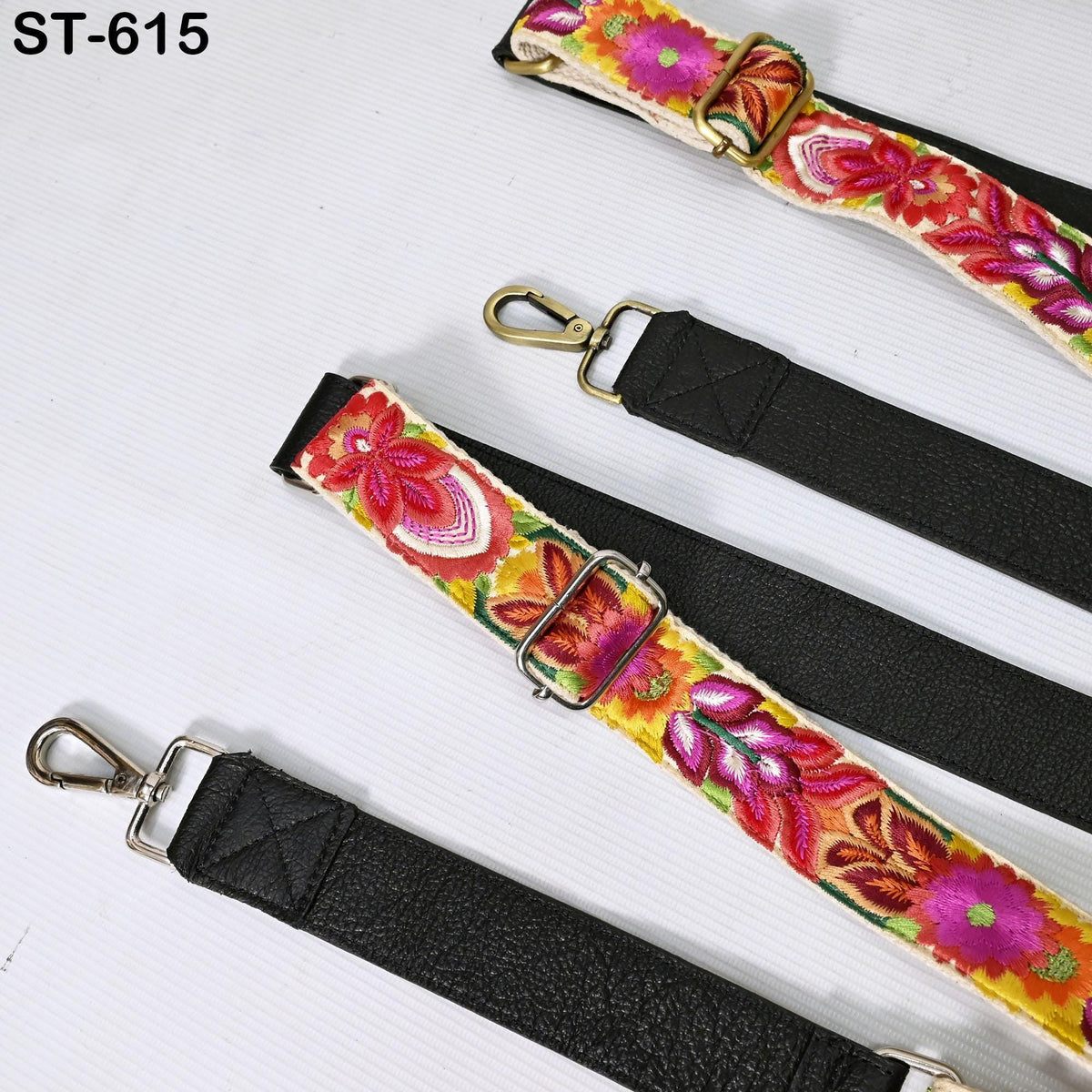 a collection of colorful, embroidered straps with metal buckles, arranged on a white surface.