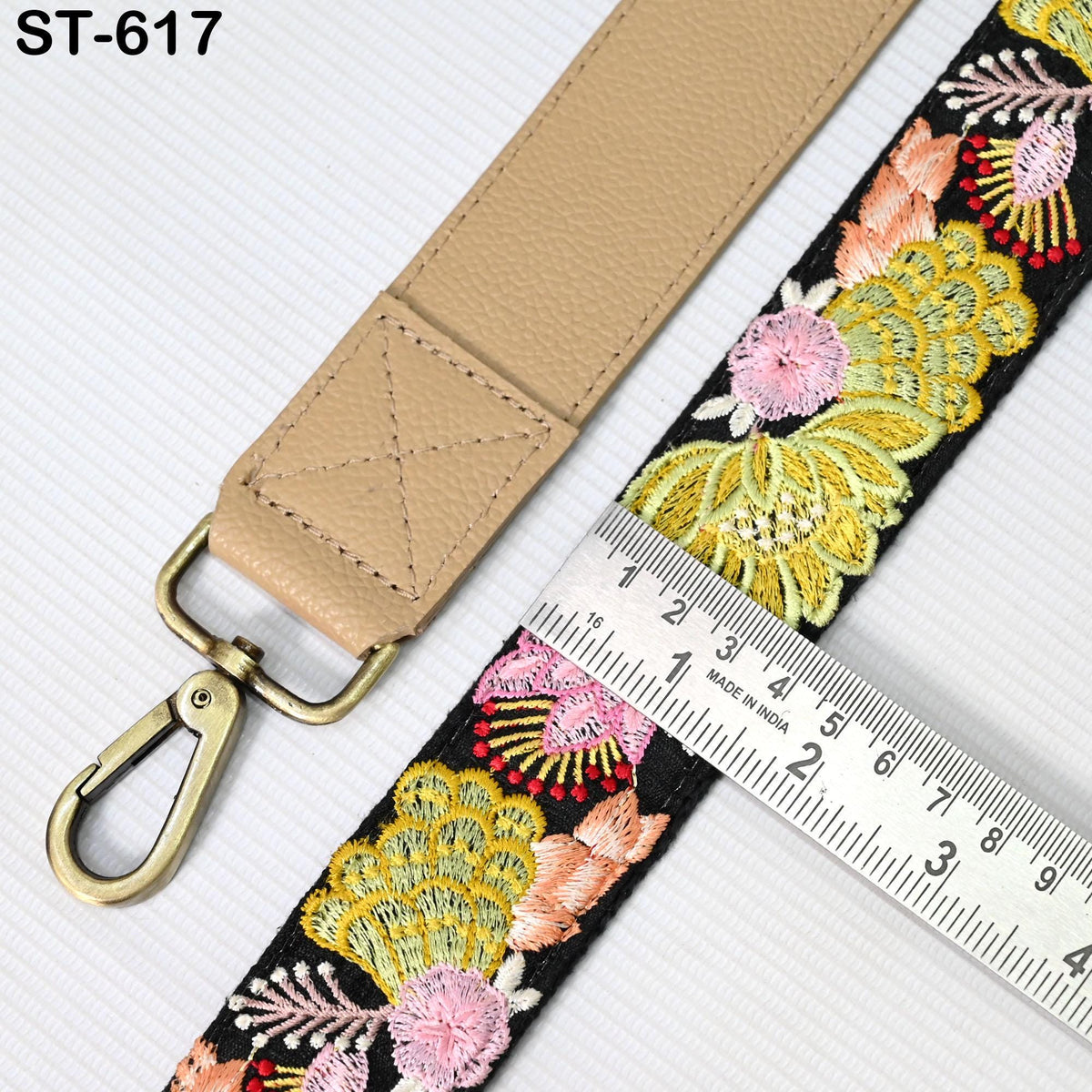 a beige leather strap with a floral pattern, and a ruler is placed next to it, indicating the strap's length.