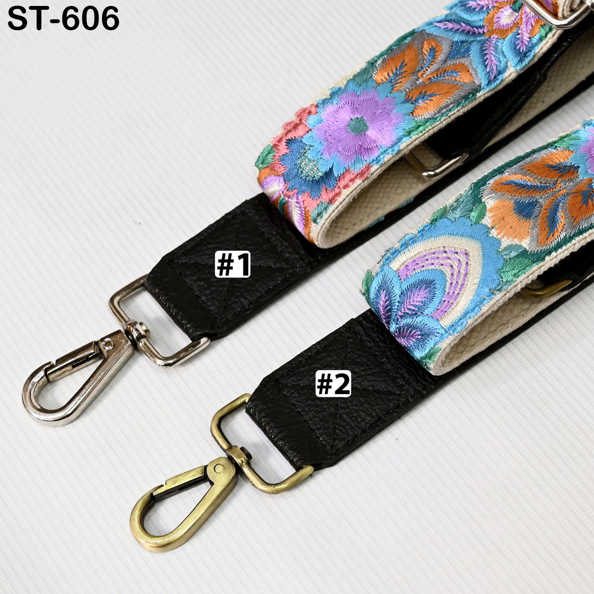 two colorful straps with floral patterns, one black and one gold, placed on a white surface.