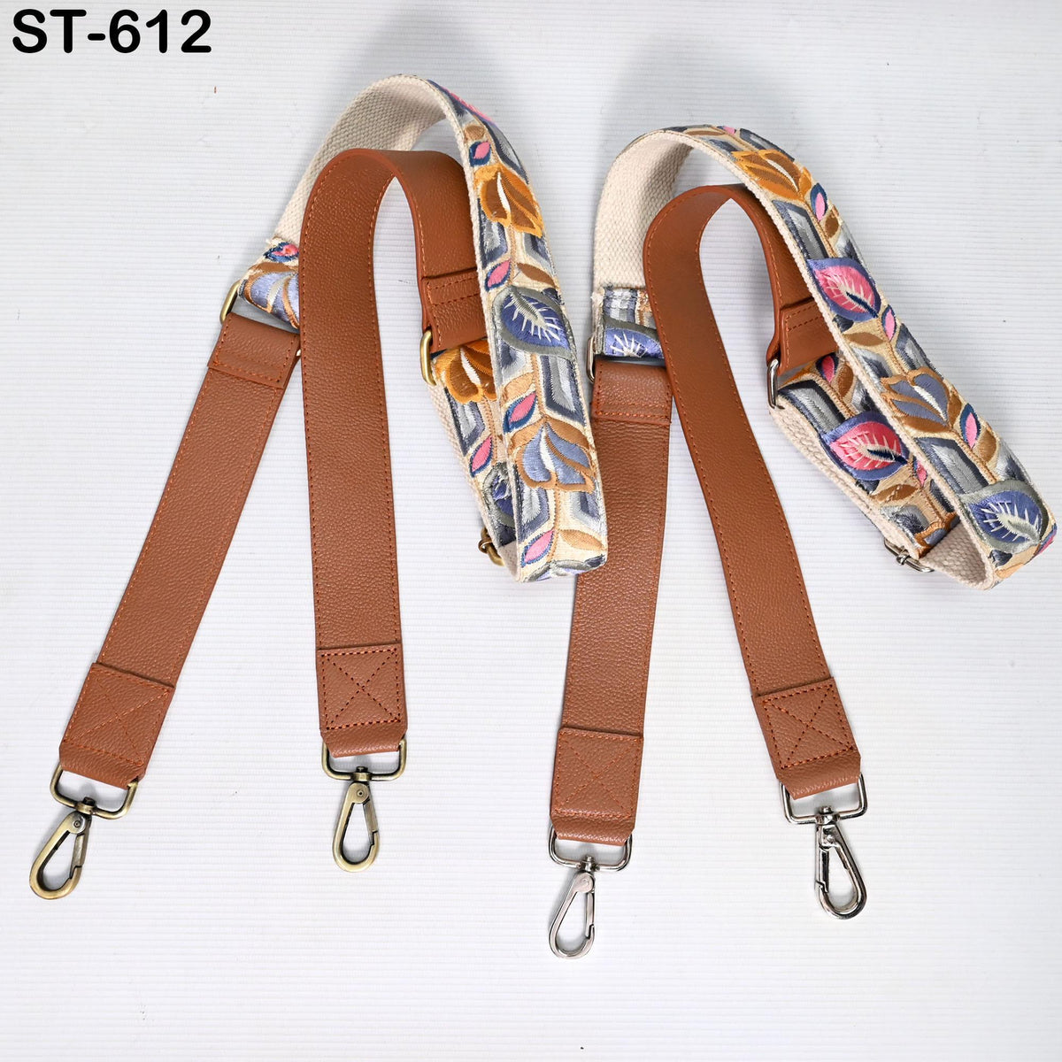 a pair of brown leather straps with colorful floral patterns, arranged on a white background.