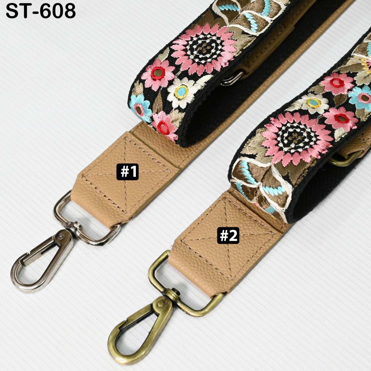 two straps with floral embroidery, one with a black strap and the other with a tan strap. The straps have metal hooks and buckles, and there are small labels on the straps indicating the number 1 and 2.
