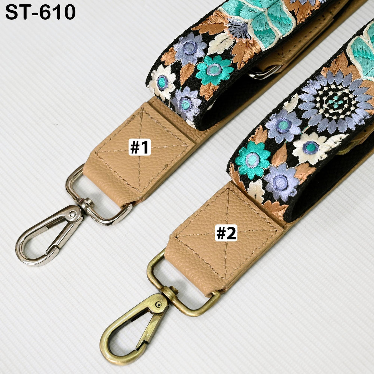 two straps with floral designs, one with a beige strap and the other with a black strap. The straps have metal hooks and buckles, and there are labels indicating the number 1 and 2 on each strap.