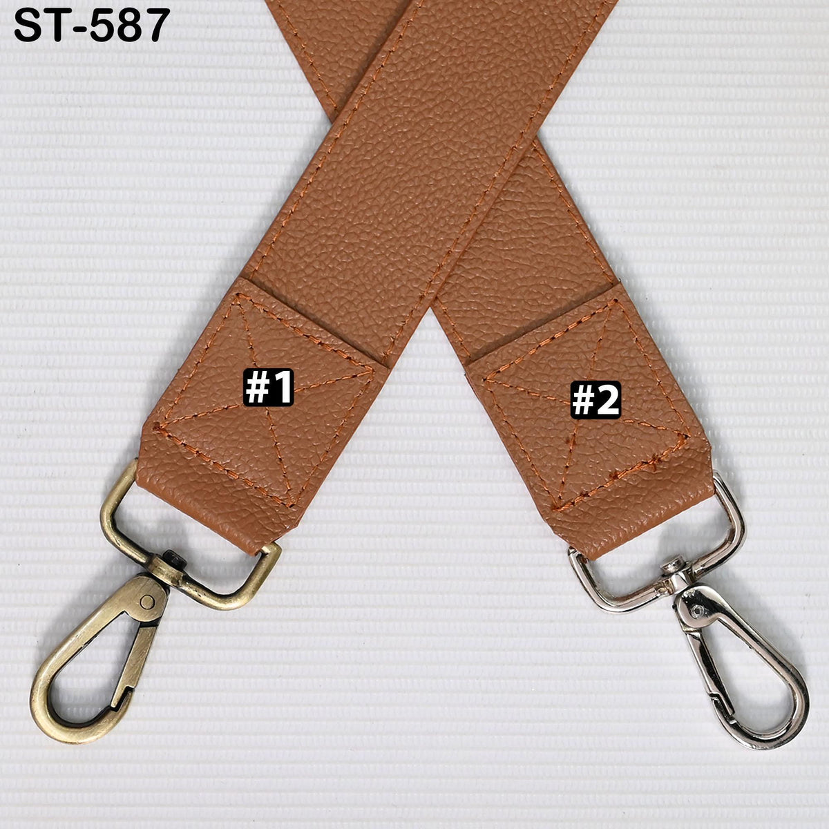 a brown leather strap with two metal hooks attached to it, placed on a white surface.