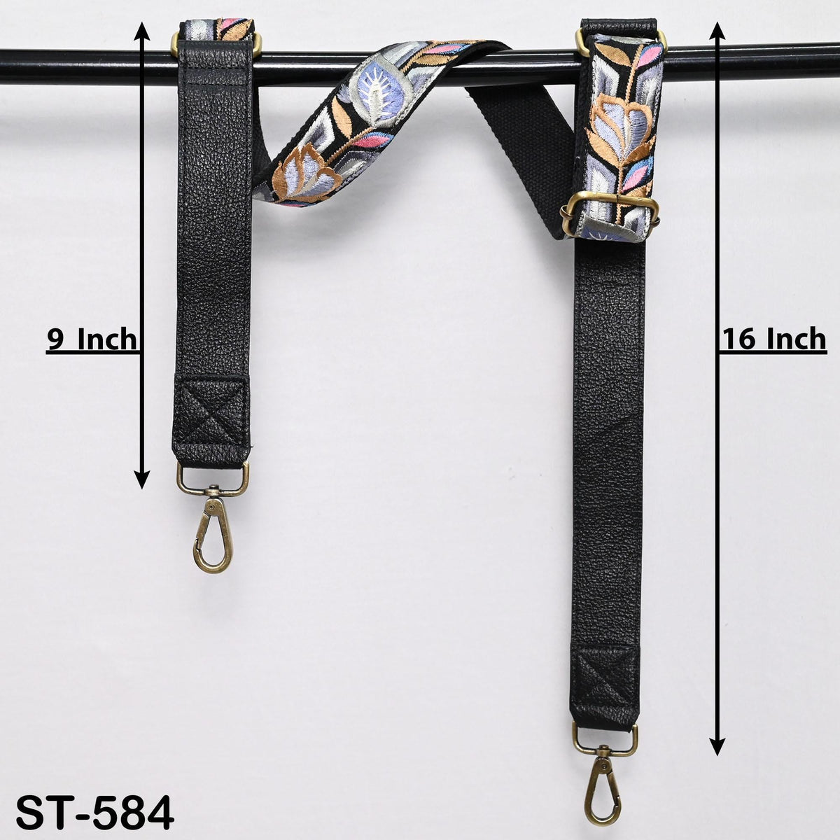 a pair of black leather straps with floral embroidery, hanging on a black rod. The straps are labeled with measurements, indicating that they are 9 inches and 16 inches long.